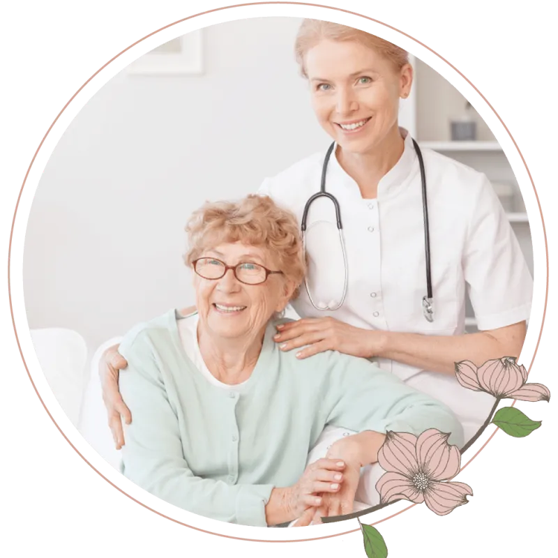 A nurse sitting next to an elderly woman on a couch 