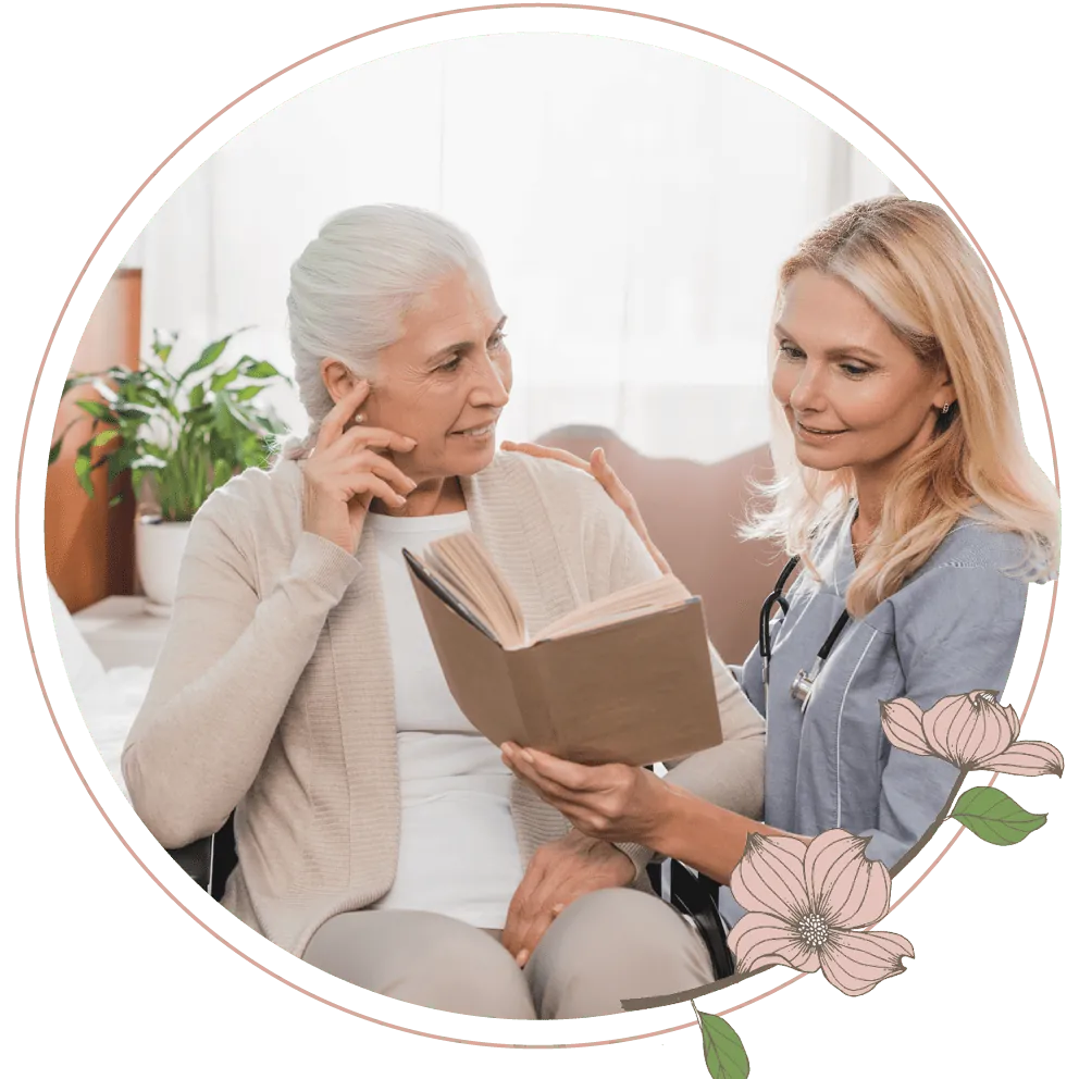 A nurse reading a book to an elderly woman
