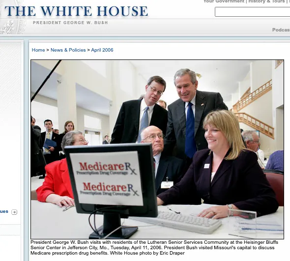 A group of people gathered around a computer monitor