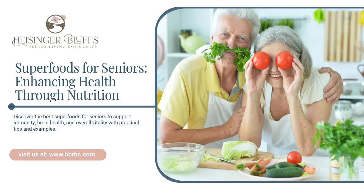 An elderly couple has fun in a kitchen, holding tomatoes over their eyes and greens as a mustache, promoting senior health.