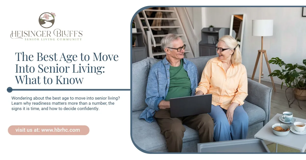An elderly couple sitting on a couch, looking at a laptop