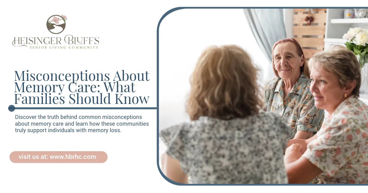 A group of older women are sitting around a table talking to each other in a memory care facility